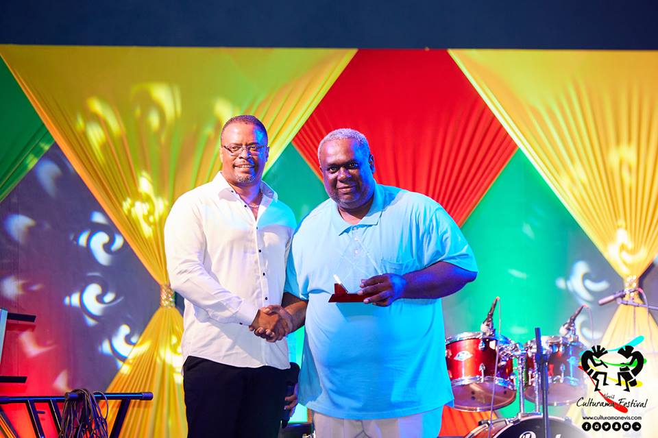 Hon. Mark Brantley, Deputy Premier of Nevis and Minister of Culture presents token of appreciation to Kemuel “Kem” Simmonds on July 04, 2017, for his long standing contributions at the Cultural Village